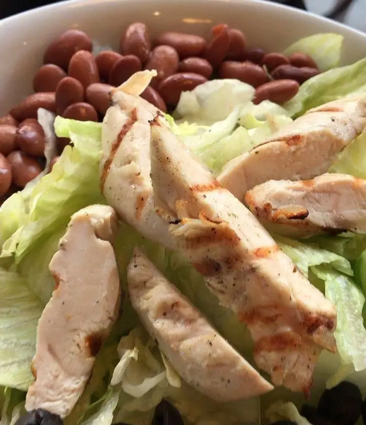 یک کاسه سالاد مرغ گریل خوشرنگ و اشتهاآور شامل فیله مرغ، کاهو تازه و لوبیا قرمز، آماده در رستوران شیرین پلو.