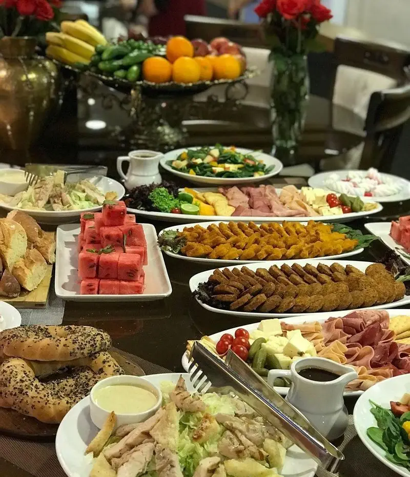 میز بوفه مجلل و کامل رستوران شیرین پلو شامل انواع غذاهای سرد و گرم، سالاد، میوه و دسرهای خوشمزه برای مهمانی‌ها و جشن‌ها.