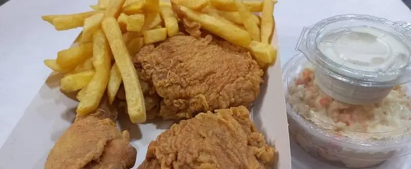 وعده فست فود لاکچری: مرغ سوخاری ترد و طلایی با سیب زمینی سرخ کرده و سالاد کلم تازه، ایده‌آل برای یک تجربه غذایی دلچسب.