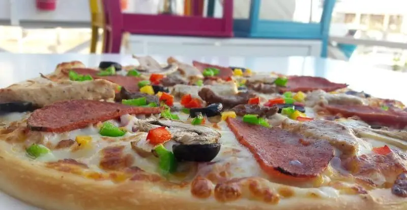 پیتزا مخلوط مجلل و خوشمزه فست فود لاکچری با پپرونی، مرغ، قارچ، زیتون و فلفل دلمه‌ای رنگی. مناسب سفارش آنلاین.