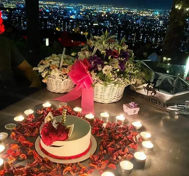 جشن تولد رمانتیک در کافه رستوران سیتی تراس با منظره شب شهر، کیک تک شاخ، گل و شمع. تجربه‌ای فراموش نشدنی.