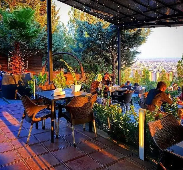 کافه رستوران سیتی تراس با فضای باز دلنشین، منظره زیبای شهر در غروب آفتاب و محیط سرسبز، مکانی ایده‌آل برای دورهمی.