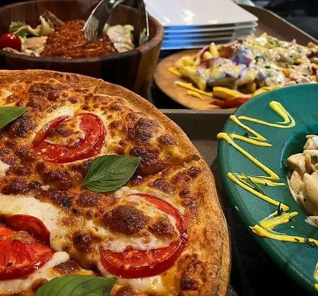 پیتزای داغ و لذیذ با گوجه و پنیر کافه رستوران سیتی تراس، به همراه سالاد تازه و غذاهای متنوع دیگر برای تجربه ای فراموش نشدنی.