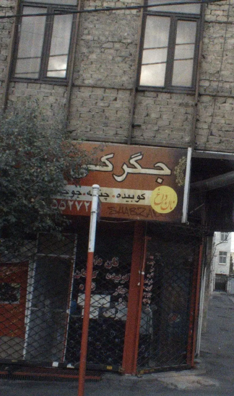 تصویر تابلوی ورودی جگر سرای تانیشلار، ارائه‌دهنده انواع کباب، جگر، کوبیده، چنجه و جوجه با نمای آجری مغازه در خیابان.