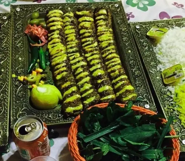 غذای اصیل ایرانی در کافی شاپ باغ نور: کباب کوبیده لذیذ با سس مخصوص، برنج زعفرانی، سبزی تازه و نوشابه در سینی‌های سنتی.