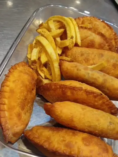 غذاهای سرخ شده طلایی شامل پیراشکی‌های گوشت و سمبوسه به همراه سیب زمینی سرخ کرده لذیذ از منوی رستوران شمشیری.