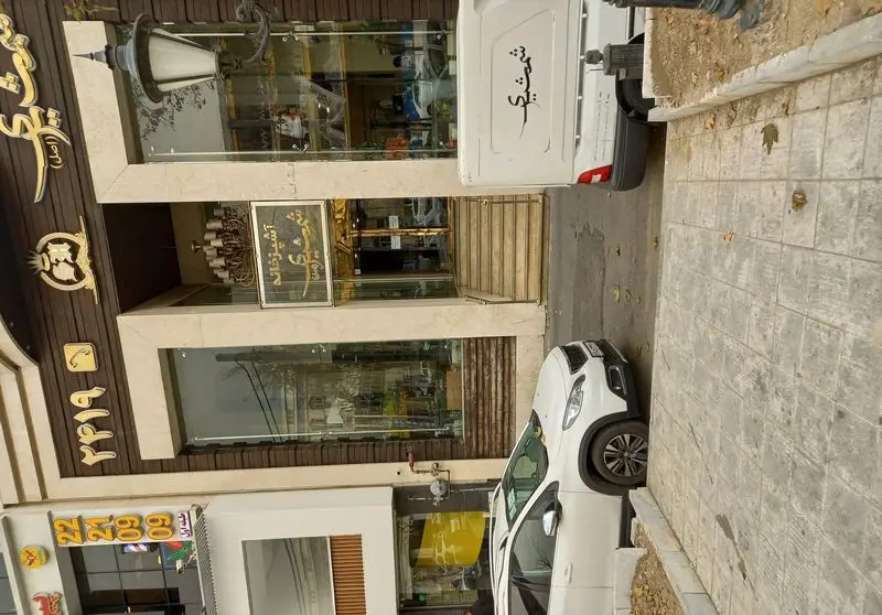 نمای بیرونی مجلل رستوران و آشپزخانه شمشیری با تابلوهای طلایی و طرح‌های سنتی، همراه با خودروی اختصاصی دلیوری شمشیری.