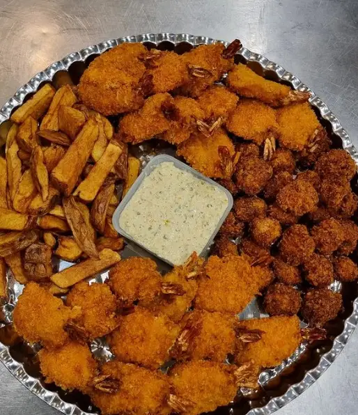 سینی بزرگ رستوران شمشیری حاوی میگوهای سوخاری مجلسی، میگو پاپ‌کورن، سیب‌زمینی سرخ‌کرده ترد و سس تارتار تازه.