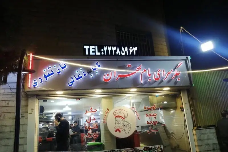 نمای شب جگر سرای بام تهران با نورپردازی، ارائه دهنده انواع کباب ذغالی، نان تنوری داغ، جگر، دل، قلوه، کوبیده، جوجه و بال. تلفن: ۲۲۳۸۵۹۶۳.