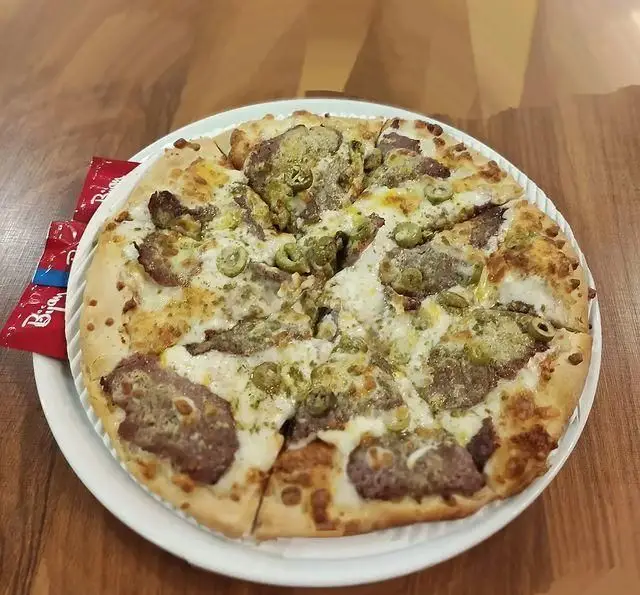 پیتزای لذیذ سفره خانه خیام با ترکیبی ویژه از تاپینگ گوشت چرخ کرده، زیتون سبز و پنیر موزارلا، بهترین انتخاب برای تجربه یک طعم بی‌نظیر.