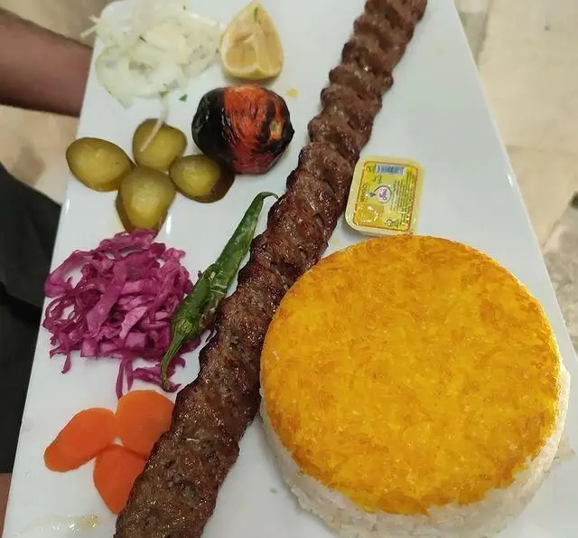 چلو کباب کوبیده ممتاز سفره خانه خیام با برنج زعفرانی، گوجه، پیاز، لیمو، خیارشور، فلفل سبز و سالاد کلم قرمز