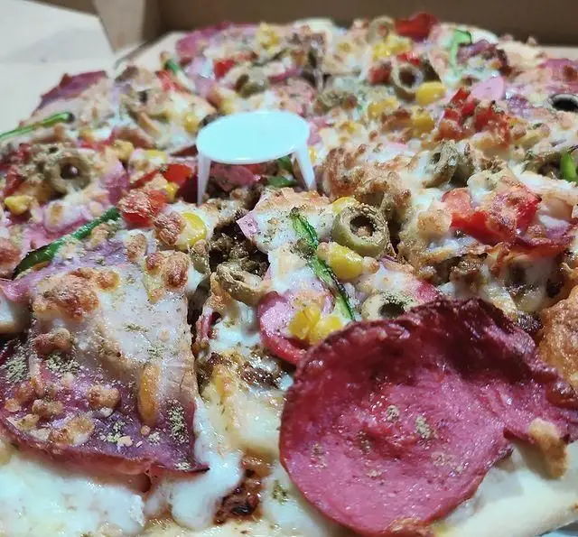 پیتزای پرملات و خوشمزه سفره خانه خیام با پنیر فراوان، کالباس، زیتون، ذرت و فلفل دلمه، آماده برای سفارش و تحویل.