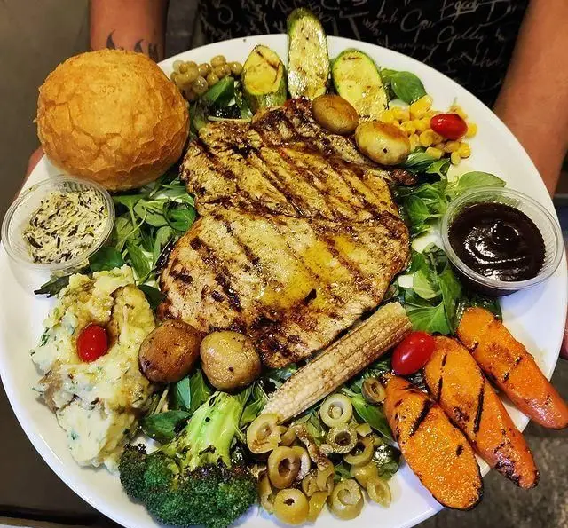 بشقاب غذای کامل سفره خانه خیام شامل مرغ گریل، نان سنتی، پوره سیب‌زمینی، ذرت، هویج، زیتون و سبزیجات تازه. یک تجربه غذایی بی‌نظیر.