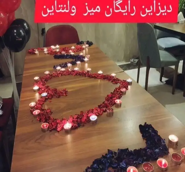 دیزاین رایگان و جذاب میز ولنتاین در سفره خانه خیام با گلبرگ‌های قرمز و شمع‌های روشن، آماده برای زوج‌ها.