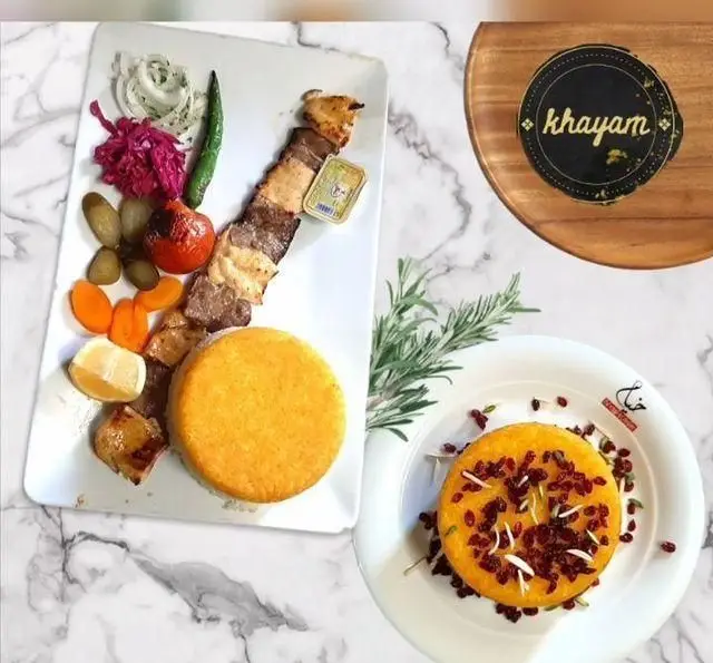 سفره خانه خیام: چلوکباب سلطانی با ته دیگ زعفرانی قالبی، زرشک پلو، گوجه کبابی، پیاز، فلفل و انواع ترشیجات.