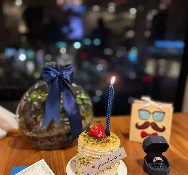 لحظات خاص و به یادماندنی جشن تولد و نامزدی با کیک، حلقه و هدیه در محیط دلنشین سفره خانه خیام با منظره شب شهر.