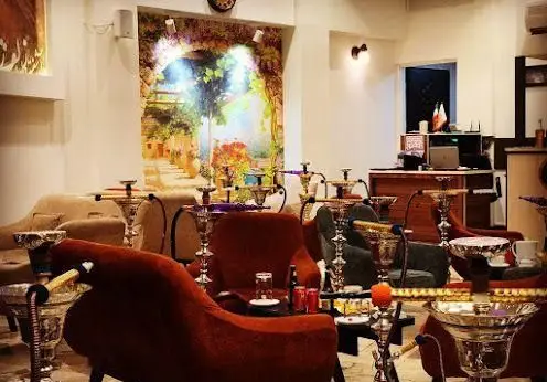 فضای دنج کافه عربی یاقوت با دیوارنگاره‌ای زیبا، مبلمان راحتی و قلیان‌های خاص. ایده‌آل برای آرامش و دورهمی.