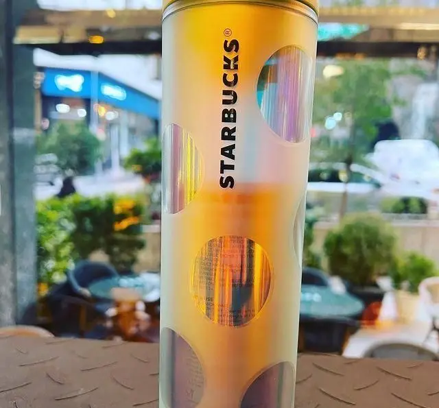 لیوان استارباکس با طراحی خاص و دایره‌های درخشان در کافه چری. لذت نوشیدنی در فضای دلنشین و شیک این کافه.