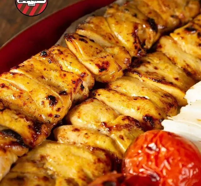 جوجه کباب خوشمزه و گریل شده کبابچی آجودانیه با گوجه و پیاز، انتخابی عالی برای دوستداران غذای اصیل ایرانی.