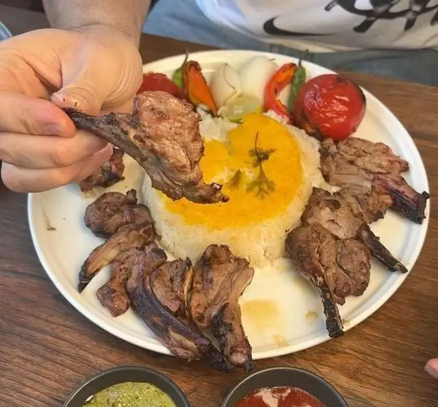 کباب شیشلیک گوسفندی و برنج ایرانی زعفرانی همراه با گوجه و فلفل کبابی در رستوران کبابچی آجودانیه.