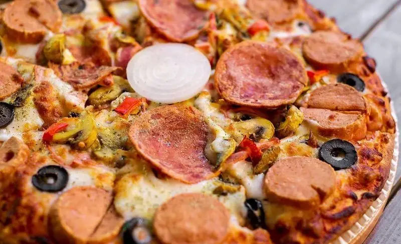 پیتزا مخلوط خوشمزه کافه رستوران کاویش با پنیر فراوان، پپرونی، سوسیس، قارچ، فلفل دلمه ای، زیتون و پیاز، انتخابی عالی برای شام.