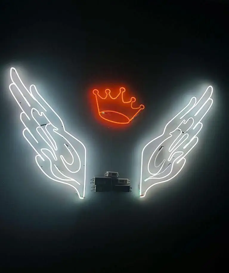 رستوران فرنگی ده و ده: دکوراسیون داخلی مدرن با نئون‌های سفید بال و تاج نارنجی، فضایی لوکس و بسیار جذاب برای تجربه‌ای فراموش‌نشدنی.