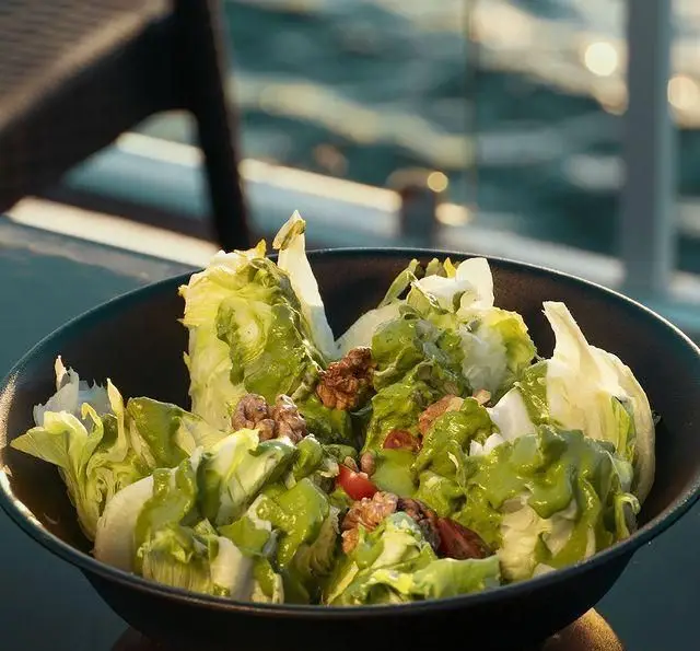 سالاد تازه و خوشمزه در کشتی رستوران رویال لانژ با منظره‌ای زیبا از دریا. ایده‌آل برای یک ناهار یا شام به‌یادماندنی و سالم.