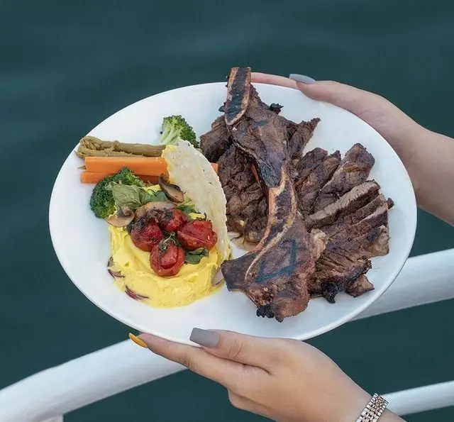 غذای ویژه کشتی رستوران رویال لانژ: بشقاب استیک و لم چاپ گریل شده، پوره، گوجه گیلاسی و سبزیجات متنوع.