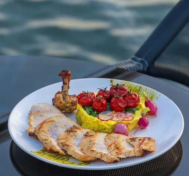 غذای لذیذ کشتی رستوران رویال لانژ: مرغ گریل با گوجه کبابی، پوره و تربچه در کنار آب، تجربه غذاخوری لاکچری.