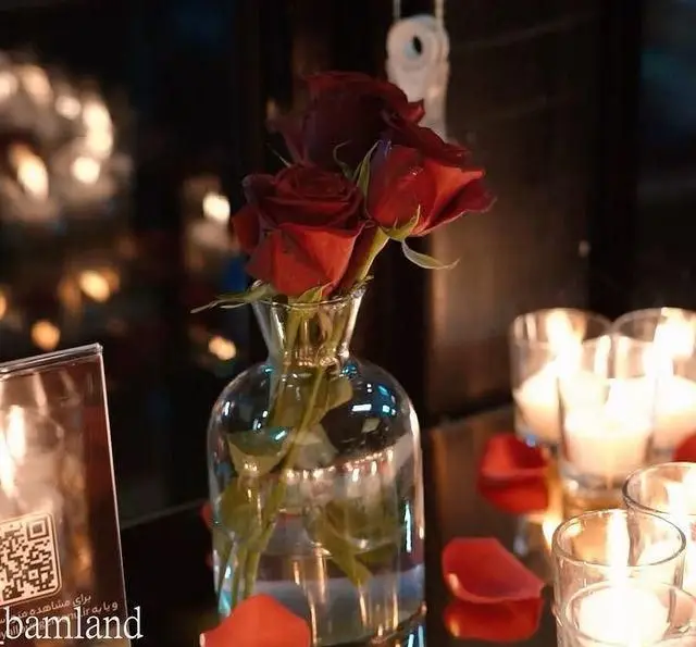 فضای گرم و رمانتیک رستوران رویال لانژ در کشتی با شمع‌های روشن، گلدان گل رز و گلبرگ‌های قرمز، ایده‌آل برای یک شام به یاد ماندنی.