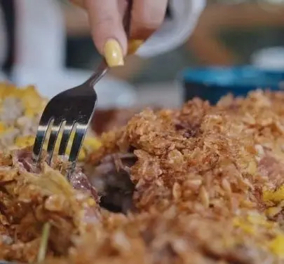 دست در حال جدا کردن تکه‌های کباب لذیذ و ترد کبابسرای شب زدگان، با روکش طلایی و خوشمزه. تجربه‌ای بی‌نظیر.