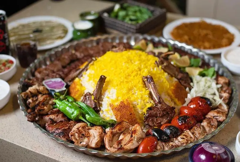 کبابسرای شب زدگان: سینی کباب ویژه شامل شیشلیک، جوجه و کوبیده با پلو زعفرانی و ته دیگ. غذای اصیل ایرانی.