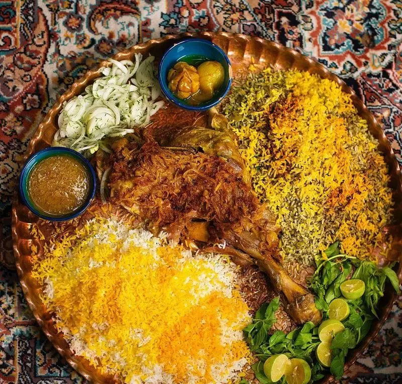 سینی مجلل ماهیچه بره کبابسرای شب زدگان با پلوهای زعفرانی و سبزی، پیاز، لیمو و سبزیجات تازه. تجربه‌ای اصیل از غذای سنتی ایرانی.