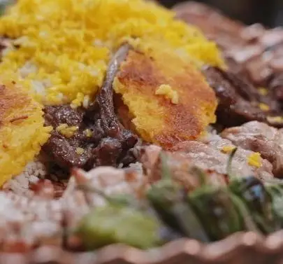 سینی شاهانه کبابسرای شب زدگان با برنج زعفرانی معطر، ته دیگ طلایی و ترد، انواع کباب تازه و خوشپخت، طعم اصیل غذای ایرانی.