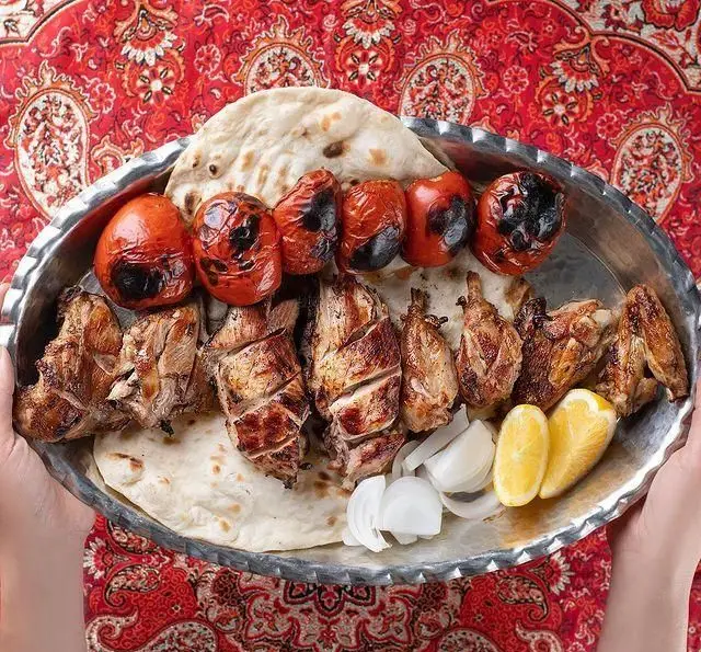 کبابسرای شب زدگان تقدیم می‌کند: سینی مجلل کباب (جوجه کباب)، گوجه کبابی، نان تازه، پیاز و لیمو. تجربه‌ای از غذای سنتی و خوشمزه ایرانی.