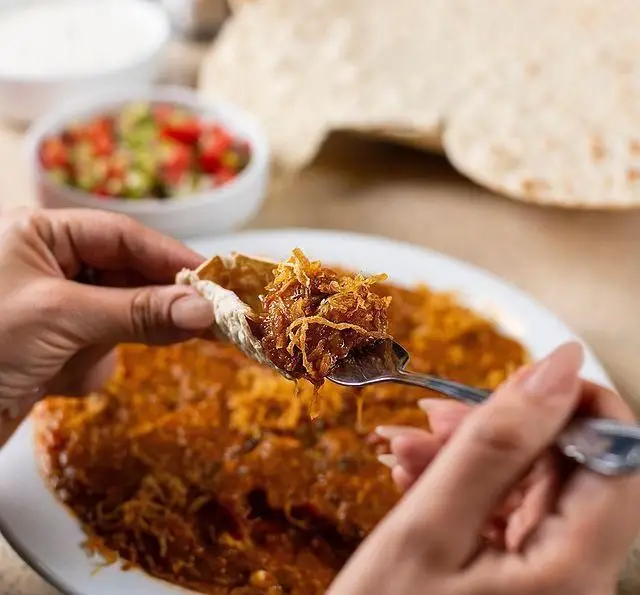 غذای خوشمزه کبابسرای شب زدگان: تکه‌های گوشت با پیاز داغ روی نان تازه، همراه با خوراک لذیذ و سالاد. تجربه‌ای دلنشین از کباب اصیل.