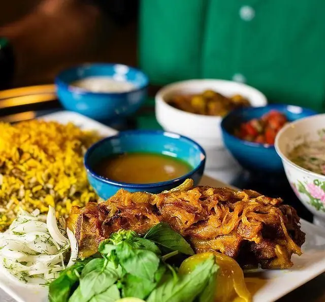 تصویر غذای اصلی چلوگوشت با پیاز فراوان و برنج زعفرانی در کبابسرای شب زدگان. شامل سبزی تازه، سالاد و ماست. بهترین انتخاب غذای سنتی ایرانی.