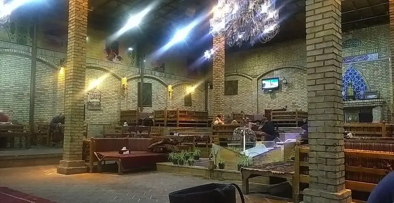 فضای داخلی سفره خانه سنتی هزار دستان با معماری آجری، تخت‌های چوبی و دکوراسیون اصیل، محیطی آرامش‌بخش برای لذت بردن از غذا و چای.