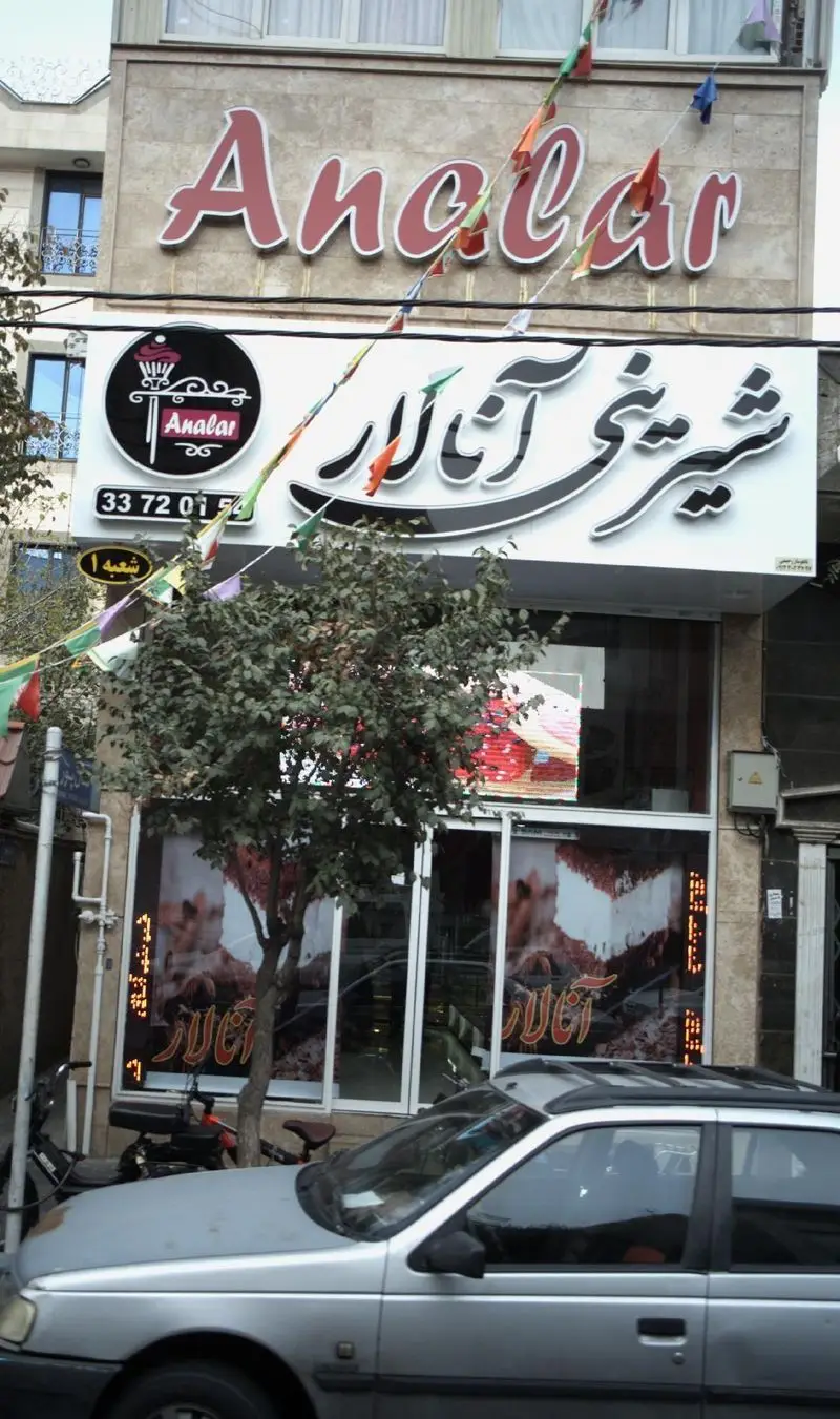 نمای بیرونی شیرینی فروشی آنالار، با تابلوهای چشمگیر فارسی و انگلیسی "Analar"، لوگوی زیبا و شماره تماس 33720154 در ورودی.