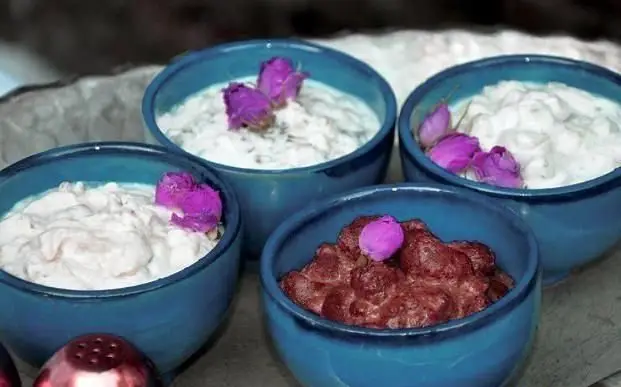 چهار کاسه فیروزه‌ای پر از ماست، پیش غذا و دسر سنتی ایرانی، مزین به گل رز، آماده برای مشتریان کبابی سلطانی شعبه 2.