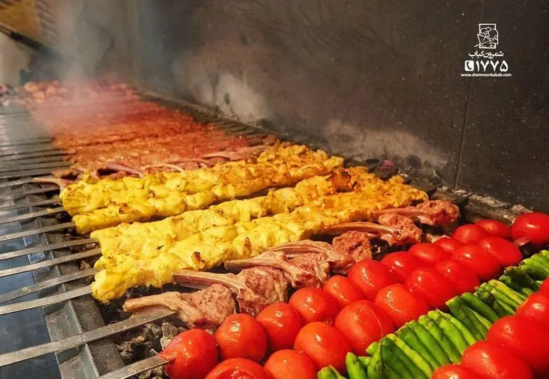 منقل بزرگ شمرون کباب با انواع کباب کوبیده، جوجه کباب زعفرانی، دنده کباب و گوجه و فلفل کبابی در حال آماده‌سازی.