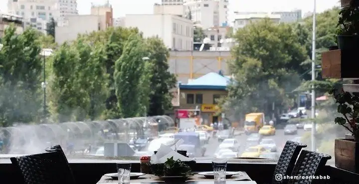 رستوران شمرون کباب: منظره دلپذیر شهری با خیابان پرتردد و درختان سرسبز، میز آرایی زیبا برای لذت بردن از کباب ایرانی.