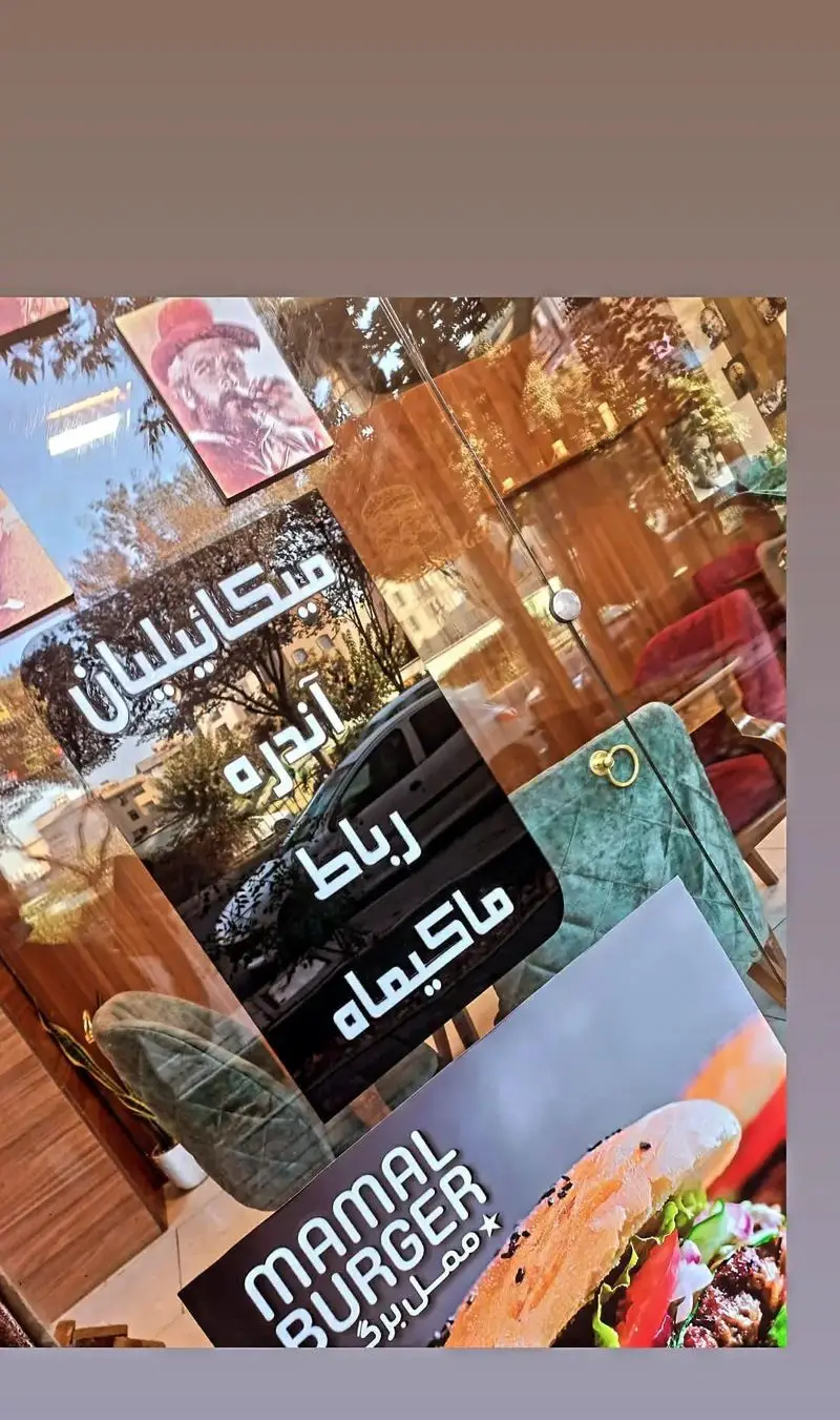 منو و تابلوی رستوران ممل برگر با نمایش شعبه ها و تصویر یک برگر خوشمزه. اتمسفر رستوران با بازتاب خیابان.