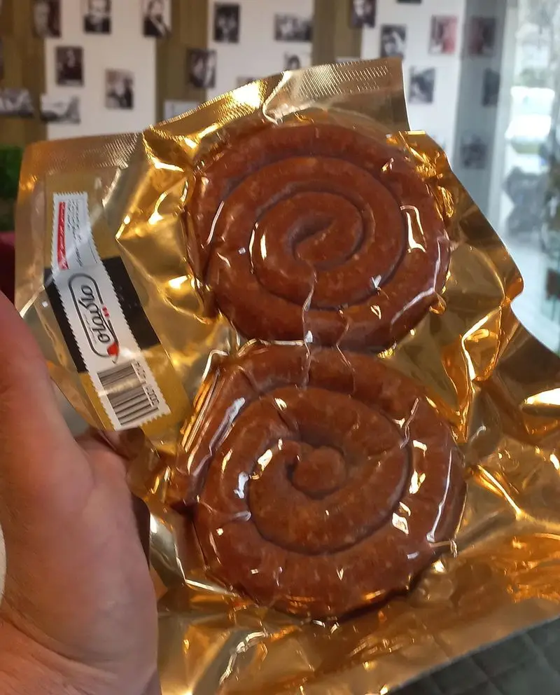 سوسیس‌های مخصوص و حلزونی شکل در بسته‌بندی طلایی وکیوم، محصولی با کیفیت برای طرفداران ممل برگر و ساندویچ‌های خاص.