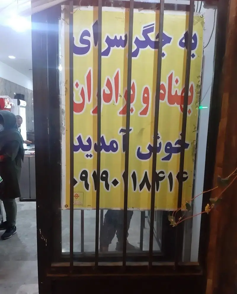 تابلوی ورودی جگرسرای بهنام و برادران، کسب‌وکار معروف کباب جگر. این تابلو زرد رنگ با نوشته‌های بنفش و قرمز پشت میله‌های فلزی دیده می‌شود.