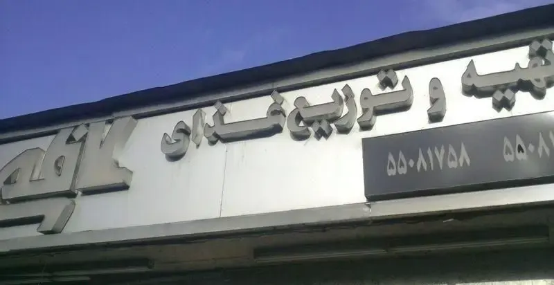 تابلوی روشن و مدرن کسب و کار توزیع غذای کاظمی با حروف برجسته سه بعدی و شماره تلفن برای خدمات تهیه و توزیع غذای با کیفیت