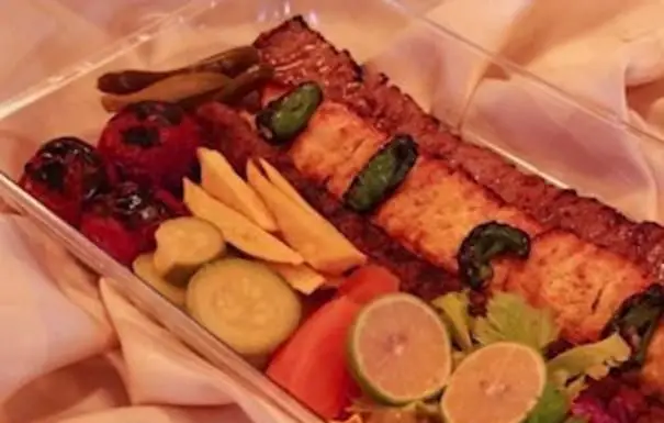 غذای خوشمزه تهیه غذا نجفی: سینی کباب کوبیده و کباب برگ با گوجه کبابی، خیارشور و لیمو. مناسب سفارش آنلاین غذای ایرانی.