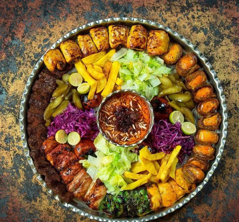 سینی کباب‌های متنوع و اشتهاآور رستوران مسینه شامل کوبیده، جوجه، چنجه، ترشی، سیب‌زمینی و خورش در مرکز.