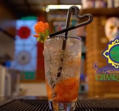 تصویری از نوشیدنی خنک با تخم شربتی، میوه و نی قلبی شکل در کافه رستوران سنتی قصر ایرانیان، مکانی دلنشین برای آرامش.