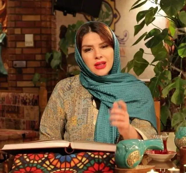 تصویری از بانویی در کافه رستوران سنتی قصر ایرانیان، با حجاب و لباس سنتی، در فضایی دلنشین و اصیل ایرانی، کنار کتاب و چای.